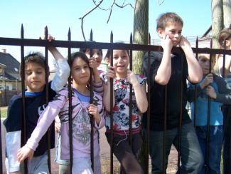 Gyerekek az iskolaudvaron a kerítésnél